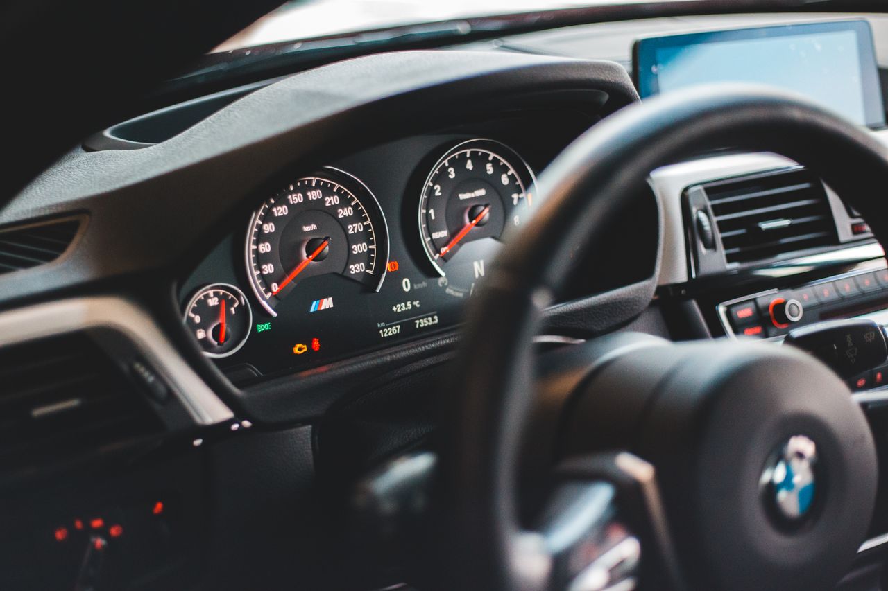 Modern black dashboard with odometer speed control and navigator inside new luxury car